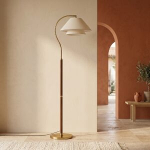 Un lampadaire vintage Wabi Sabi en bois et abat-jour en tissu, avec un pied doré et un style élégant, posé dans une pièce chaleureuse aux murs beiges et terracotta.