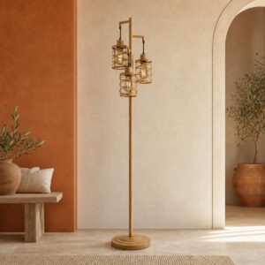 Un lampadaire style incandescent industriel 3 cages avec variateur en bois clair, avec trois abat-jour grillagés, posé dans un salon aux murs beige et terracotta.