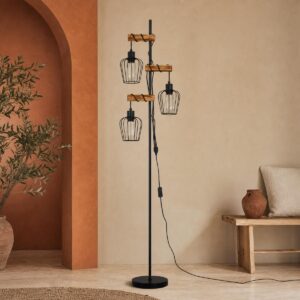 Un lampadaire style incandescent industriel bois métal douilles E27 noir avec trois ampoules suspendues, dans un salon au décor beige et bois.