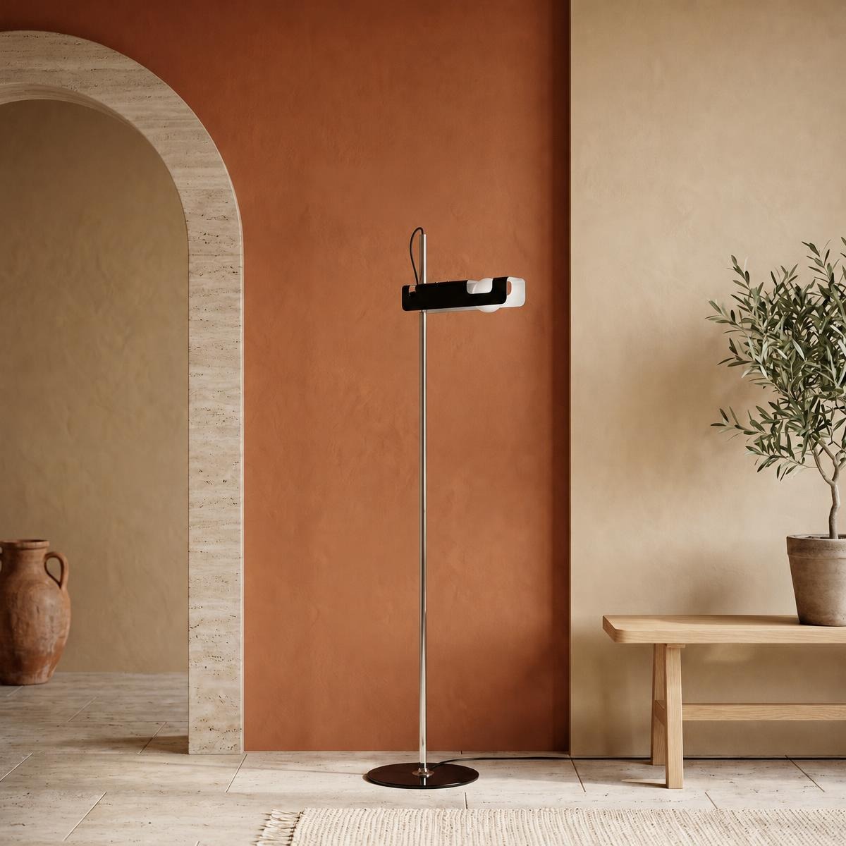 Un lampadaire industriel au style créatif en métal, avec pied rond et tête orientable, posé dans un intérieur moderne aux murs beige et terracotta.