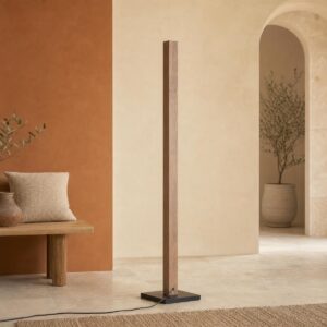 Un lampadaire avec variateur colonne bois LED 7 températures posé dans un salon beige, avec une forme fine en bois et un pied noir.